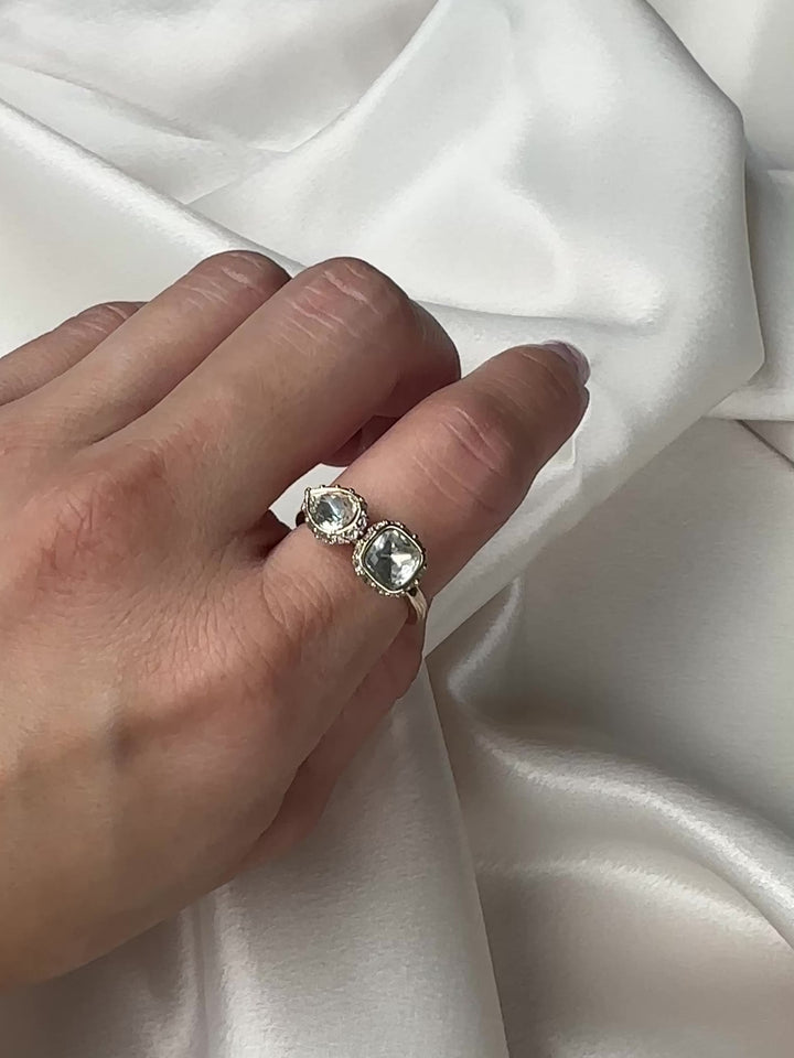 Gold ring with two clear gemstones